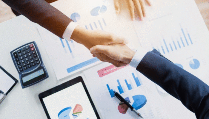 Business handshake over financial documents